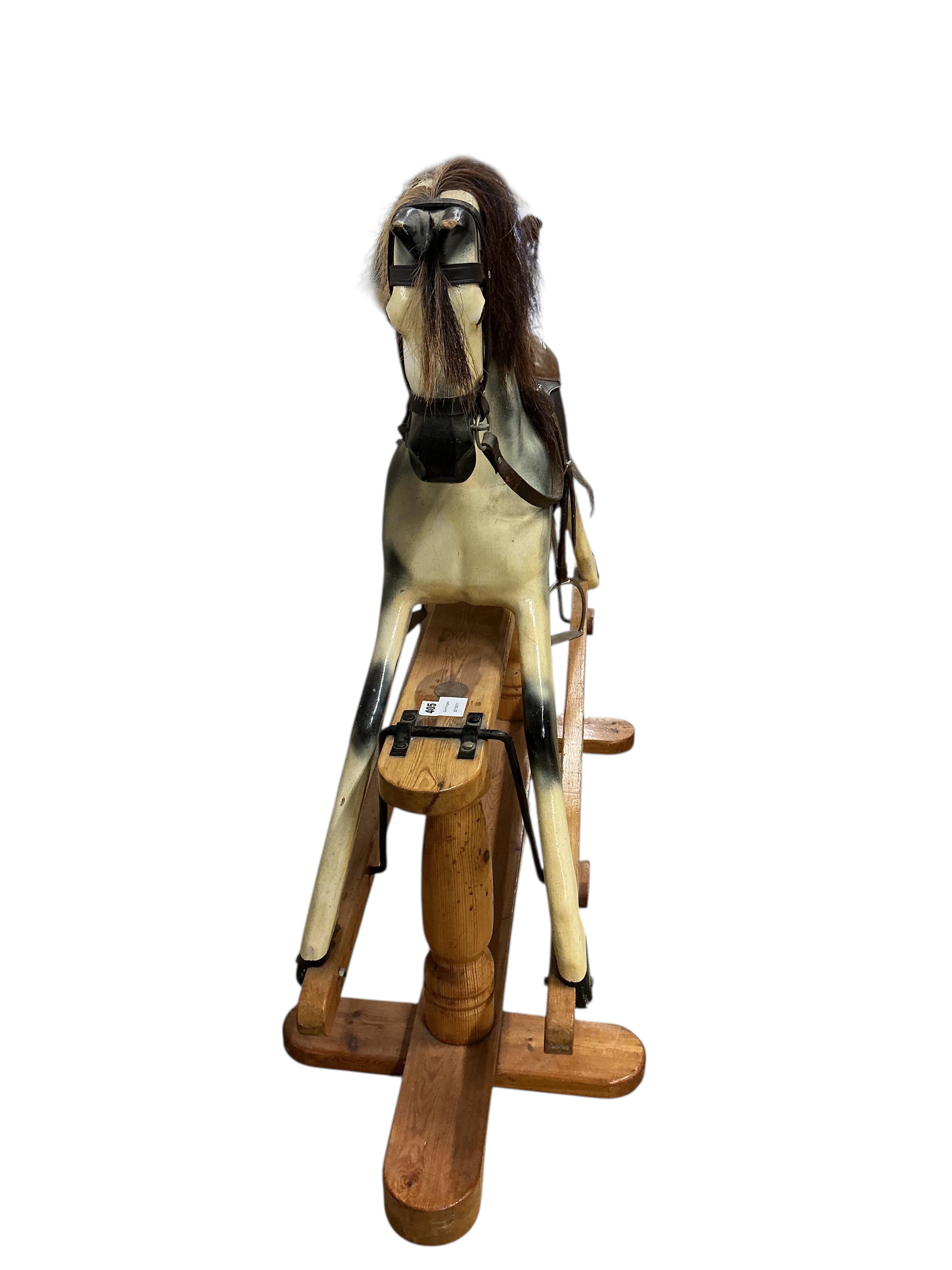A modern dapple grey rocking horse, unsigned, on a pine base, height to the top of the head 109cm, overall length 136cm